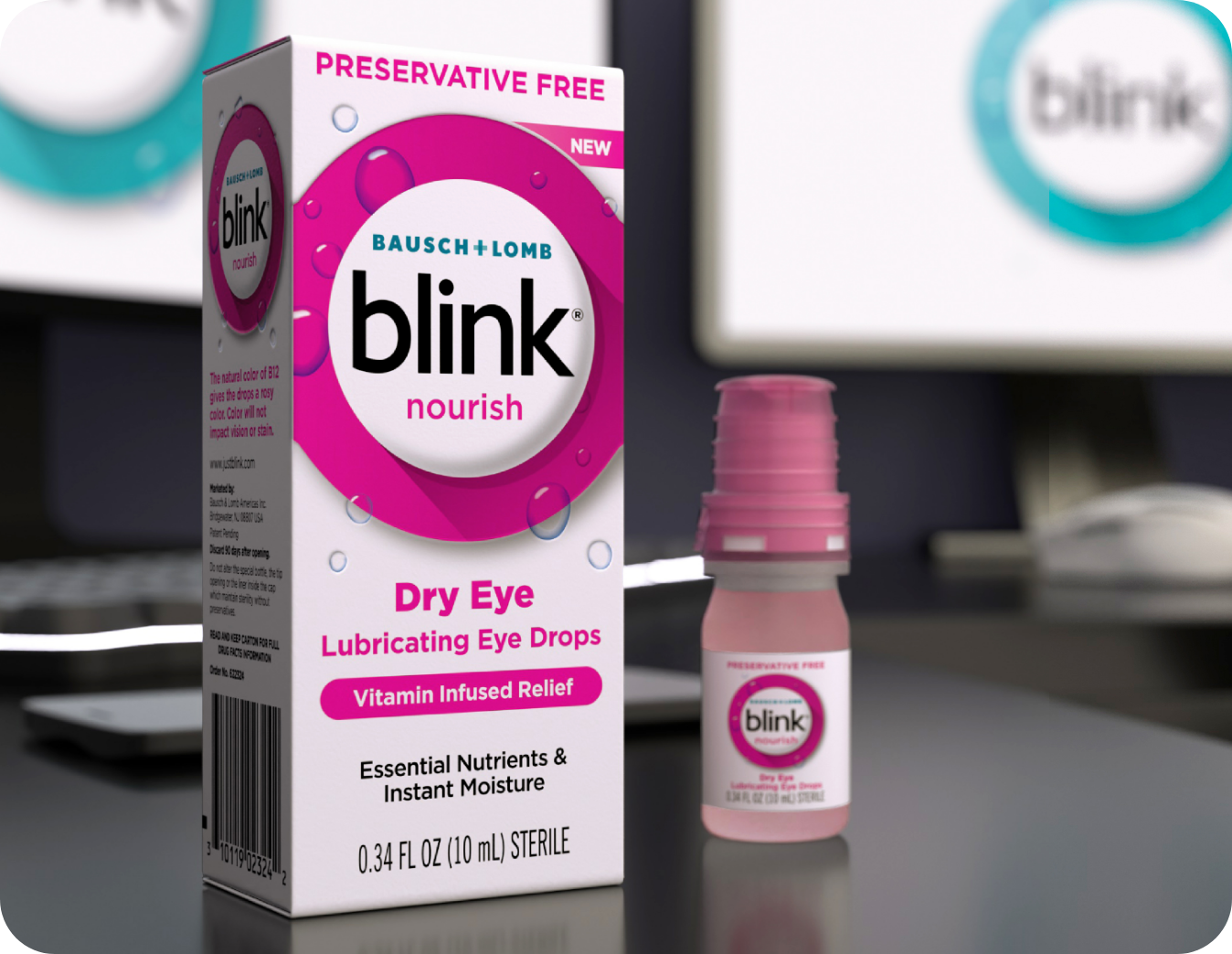 Blink Nourish Lubricating Eye Drops bottle and package on a desk in front of a computer monitor